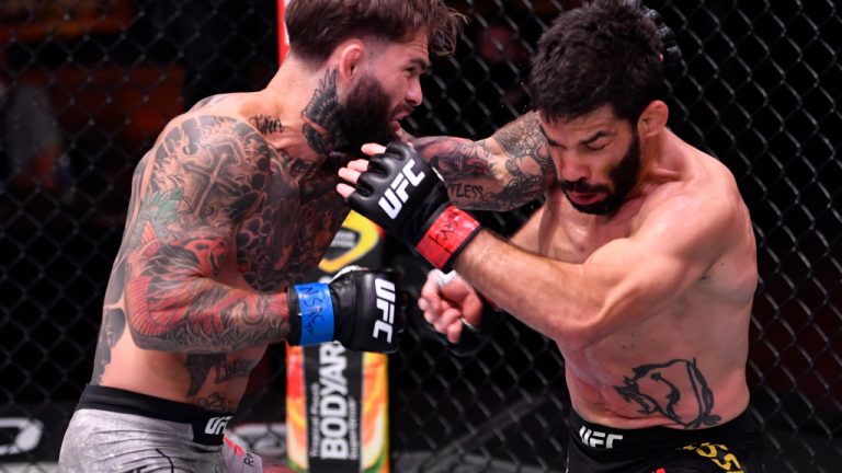 LAS VEGAS, NEVADA - JUNE 06: (L-R) Cody Garbrandt punches Raphael Assuncao of Brazil in their bantamweight bout during the UFC 250 event at UFC APEX on June 06, 2020 in Las Vegas, Nevada. (Photo by Jeff Bottari/Zuffa LLC)